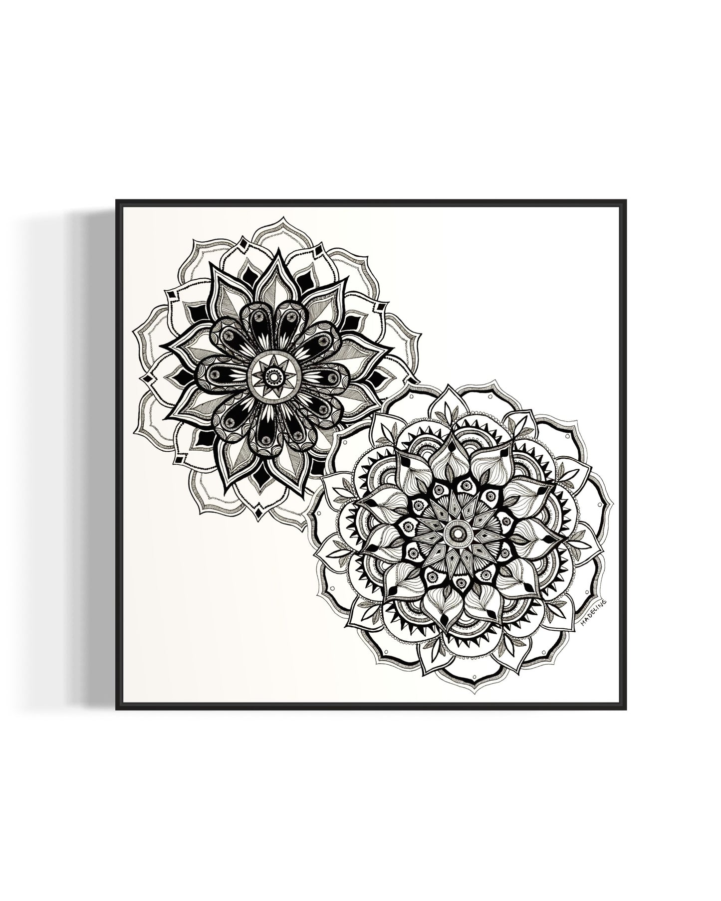 Framed artwork of two black and white mandala flower designs on a white background