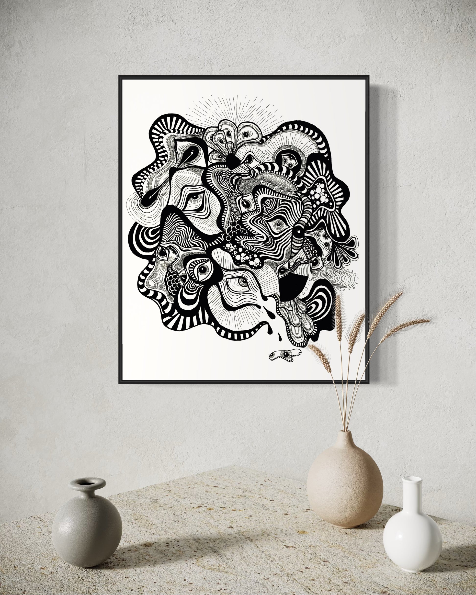 Framed black and white abstract artwork filled with eyes and whimsical linework patterns on a white background
