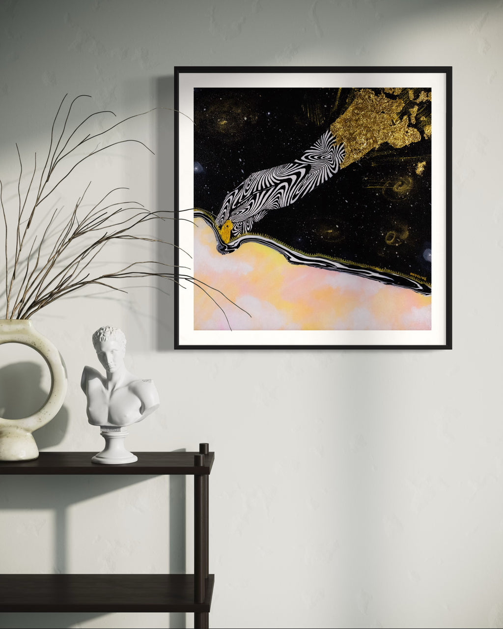 Framed artwork of an abstract black and white hand unzipping the universe on a space background with a pink sky and gold accents.