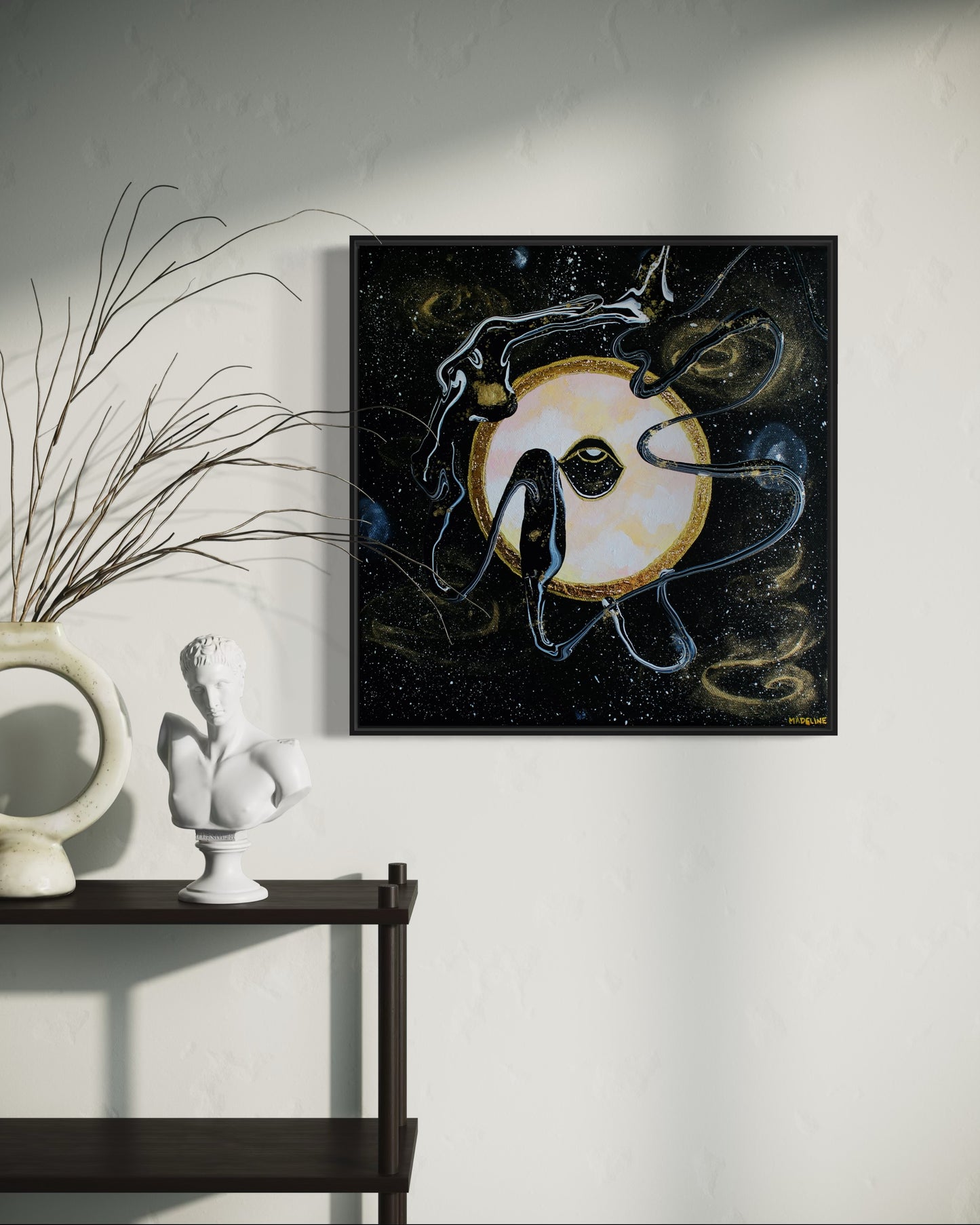 Framed black and gold artwork of a celestial night space scene with a planet and eye against a starry background.