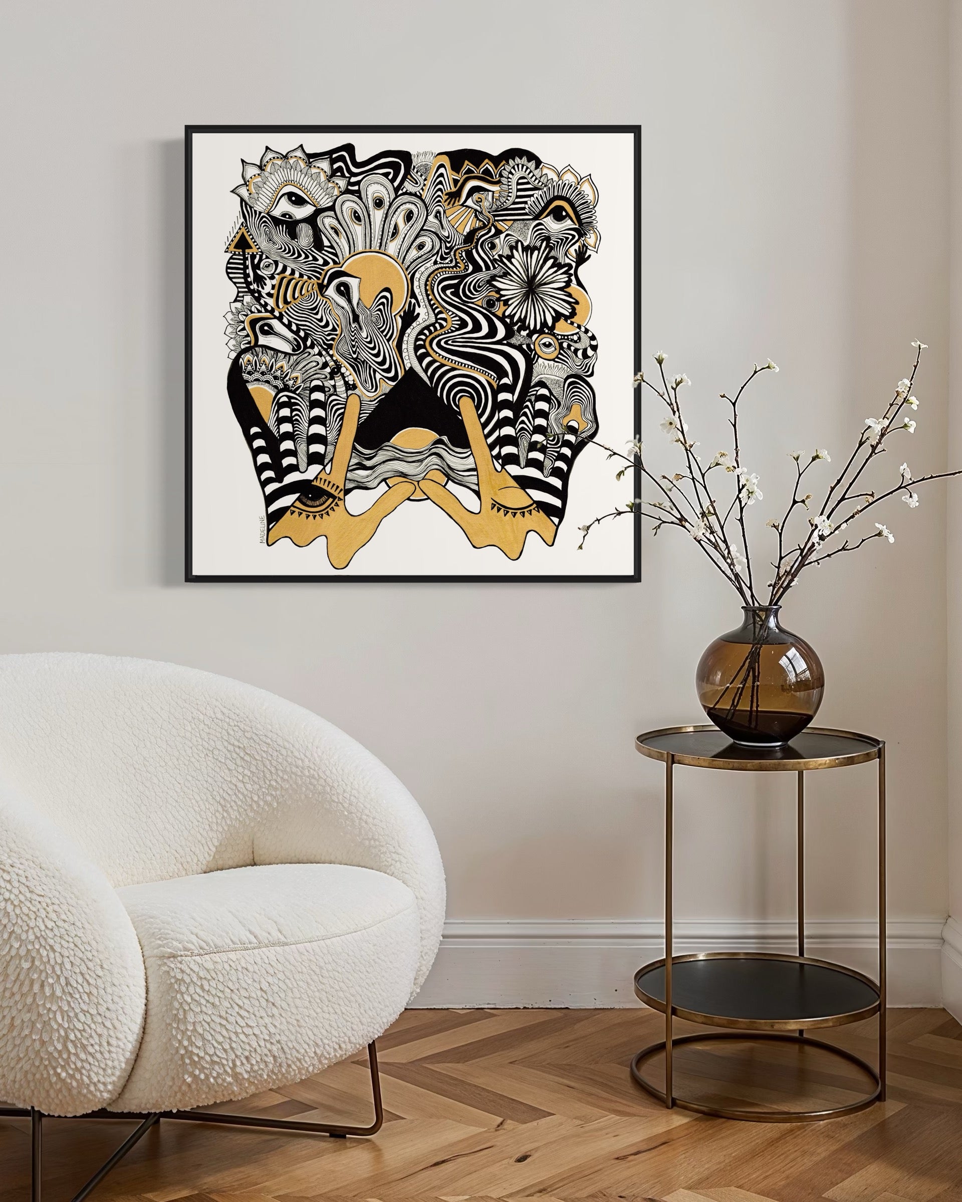 Framed abstract artwork with black, white, and gold designs coming out of two gold hands and fine linework on a white background