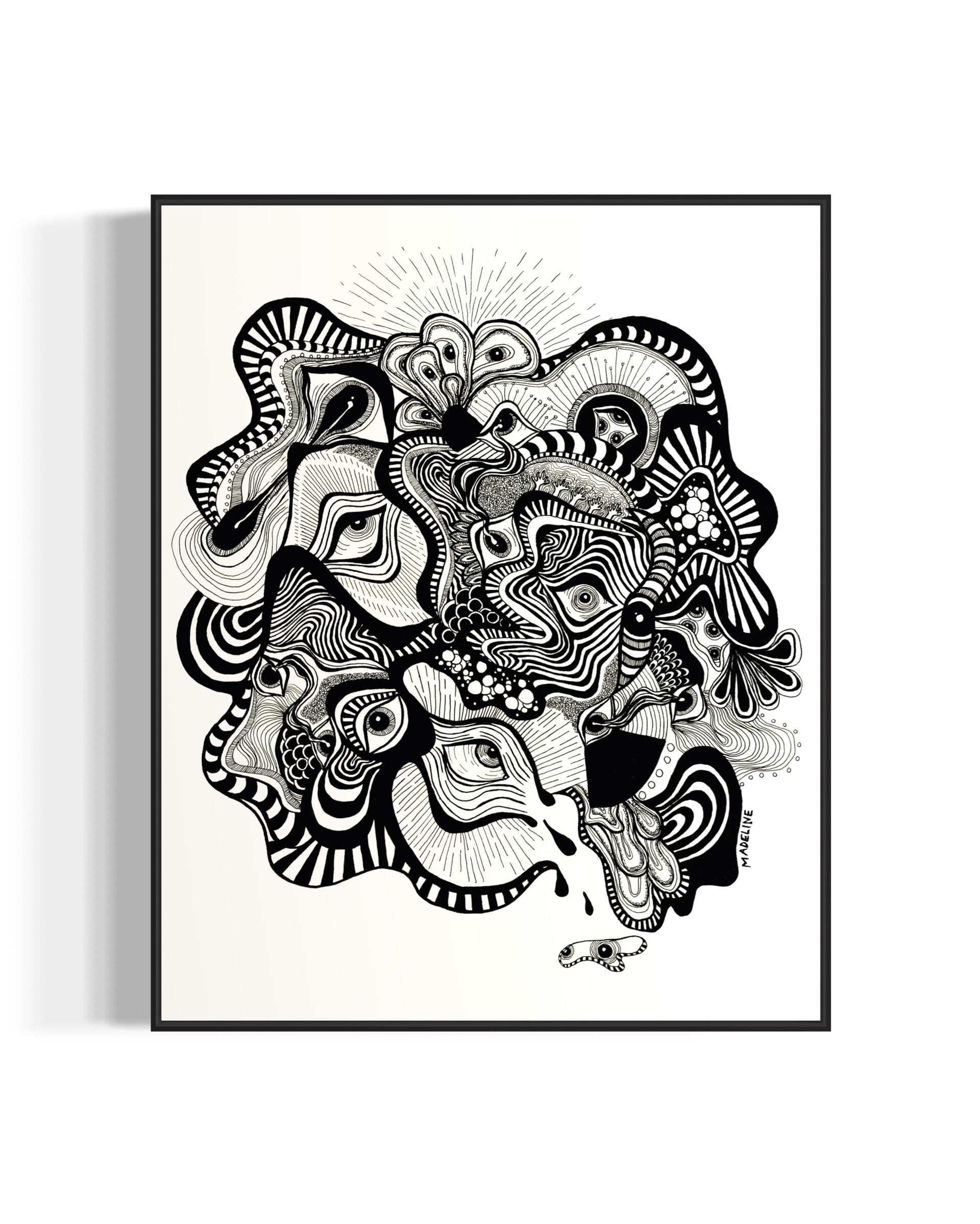 Framed black and white abstract artwork filled with eyes and whimsical linework patterns on a white background
