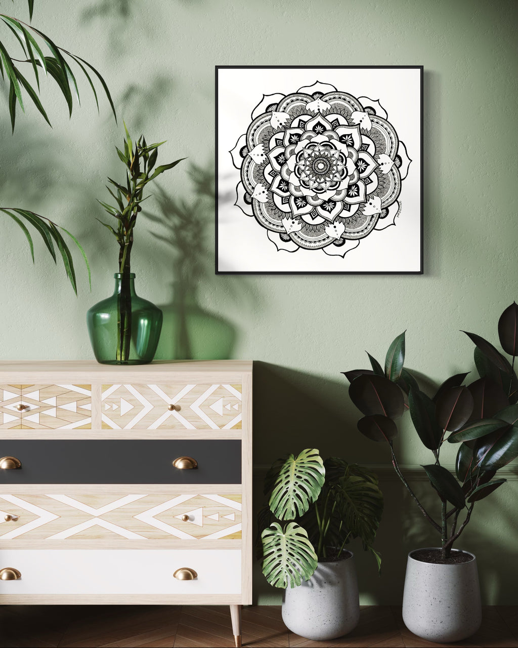 Black and white mandala art print in a black frame on a white background