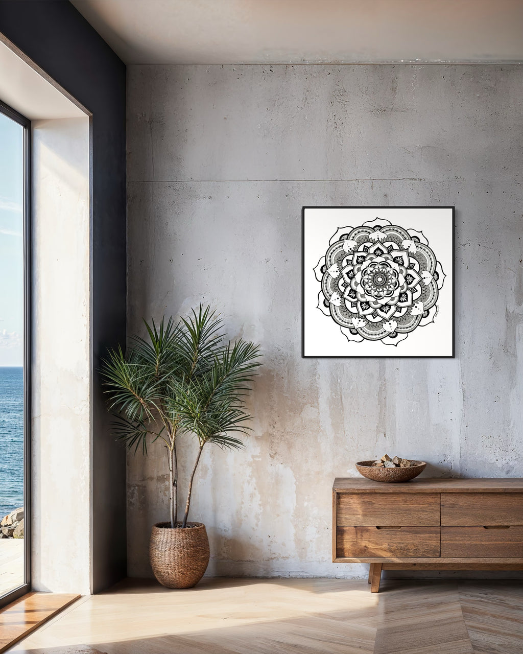 Black and white mandala art print in a black frame on a white background