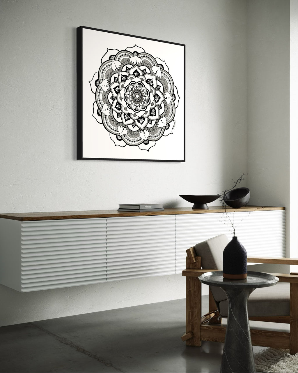 Black and white mandala art print in a black frame on a white background