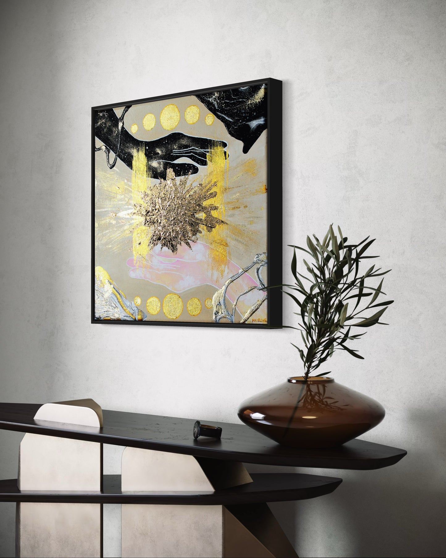 Framed abstract artwork of hands filled with the sky, an exploding gold star and geometric shapes on a tan background.