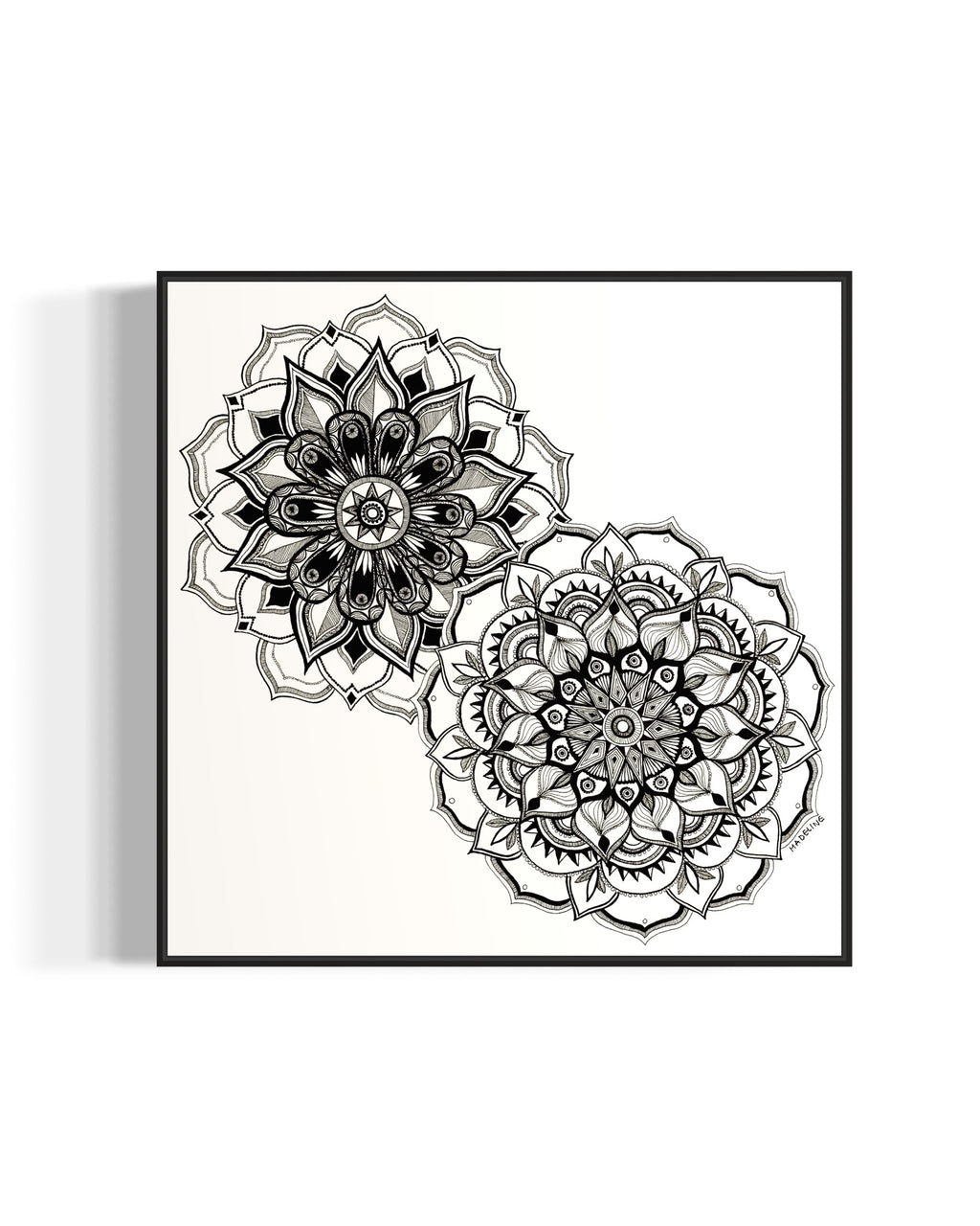 Framed artwork of two black and white mandala flower designs on a white background