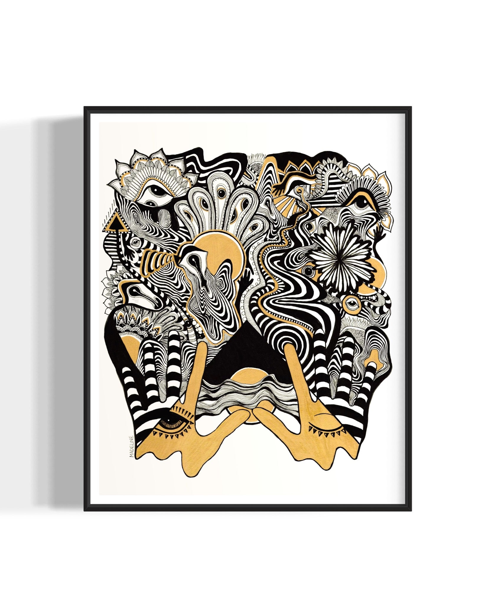 Framed abstract artwork with black, white, and gold designs coming out of two gold hands and fine linework on a white background