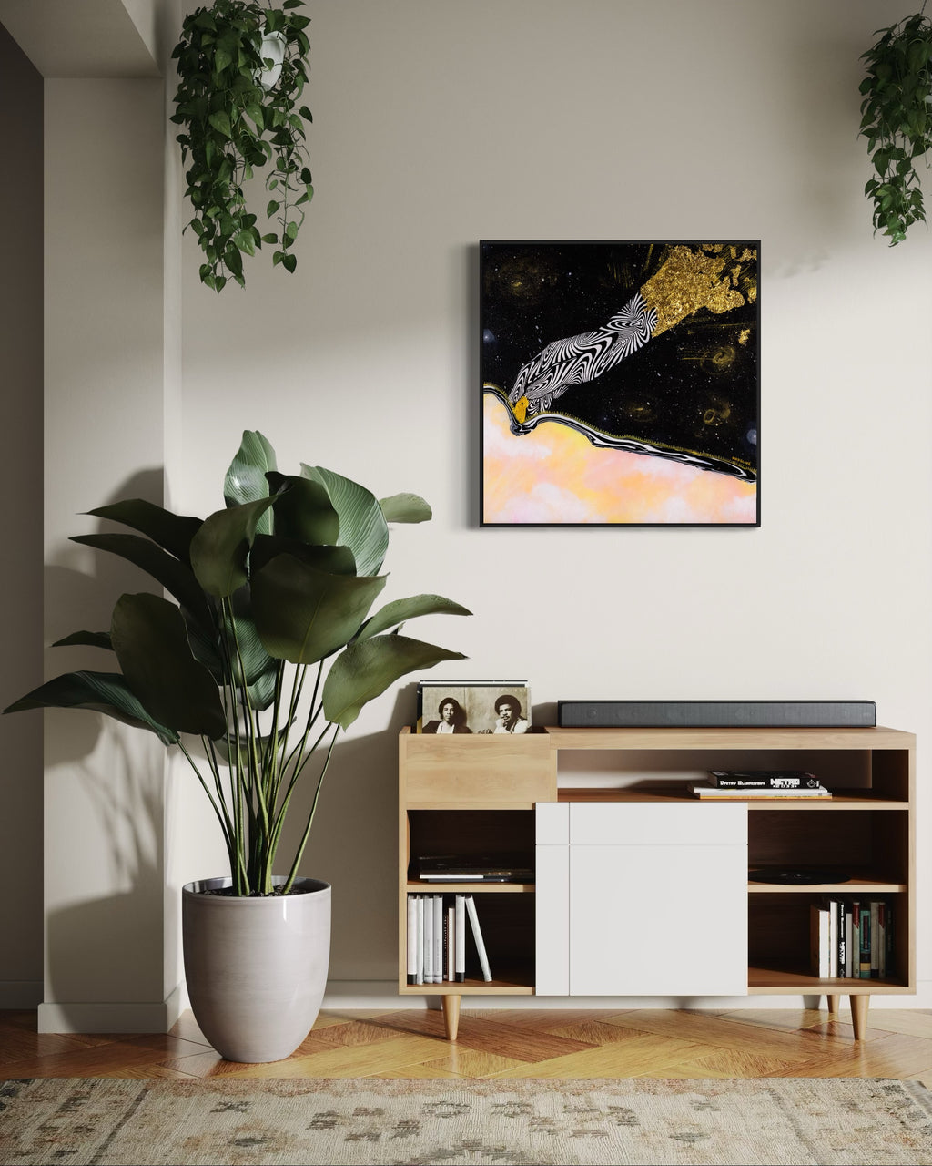 Framed artwork of an abstract black and white hand unzipping the universe on a space background with a pink sky and gold accents.