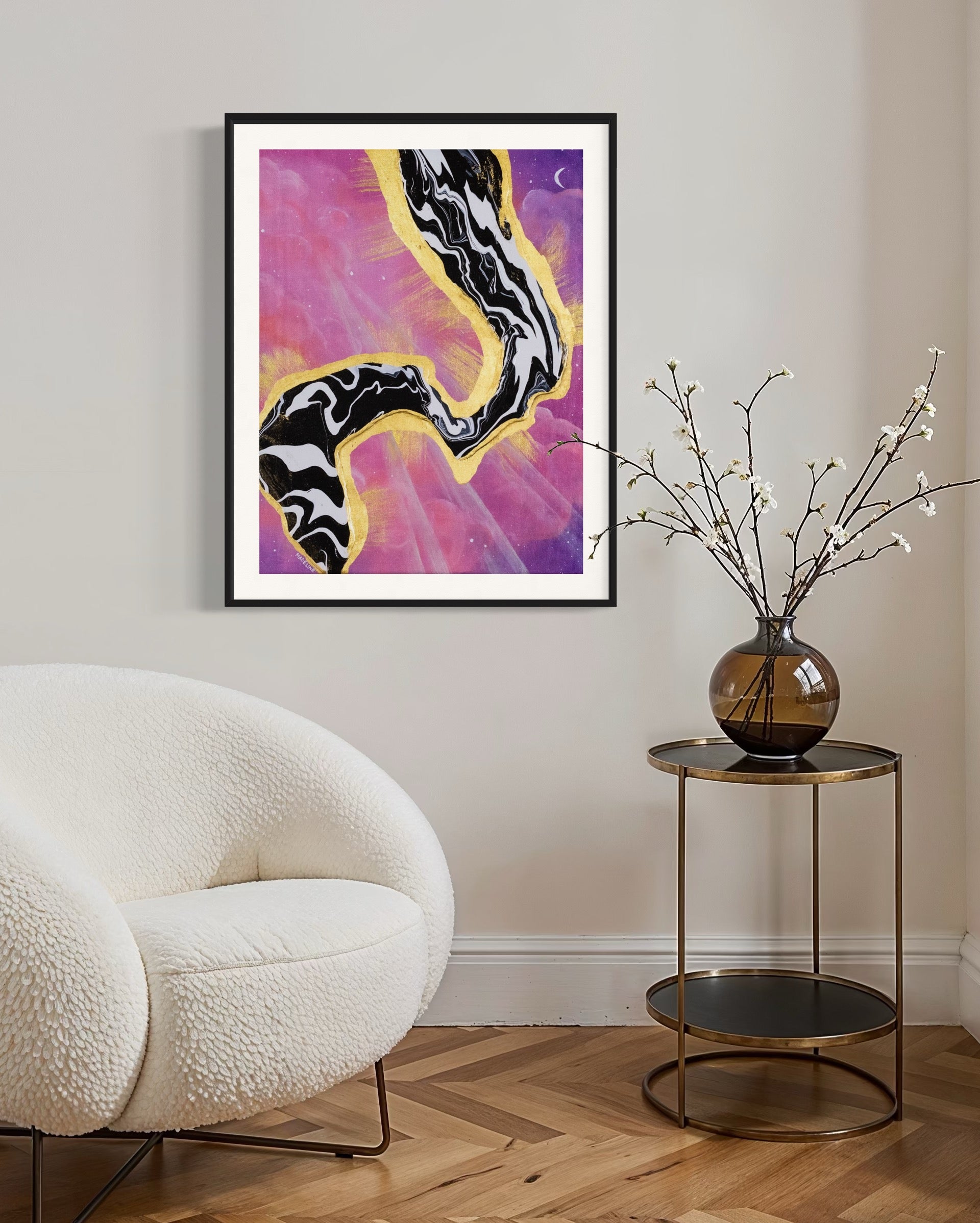 Framed artwork with abstract black and white fluid design on a pink and purple sky background with a moon and gold leaf rays