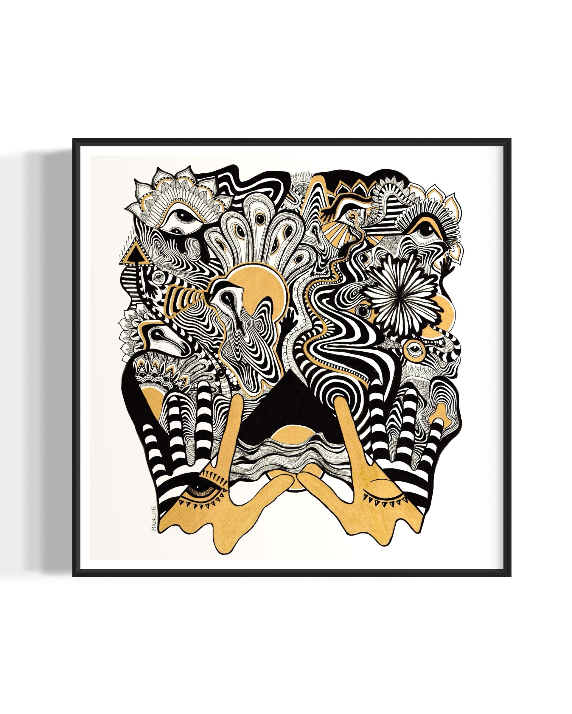 Framed abstract artwork with black, white, and gold designs coming out of two gold hands and fine linework on a white background